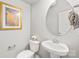 Well-lit half bath featuring a toilet, sink, and decor at 554 Amalfi Dr, Davidson, NC 28036