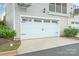 Two car garage with an adjacent manicured lawn and landscaping at 554 Amalfi Dr, Davidson, NC 28036