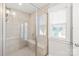 Bright shower area featuring glass doors, tile surround, and bench at 554 Amalfi Dr, Davidson, NC 28036