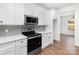 A kitchen showcases white cabinets, stainless steel appliances, a stylish backsplash, and hardwood floors at 606 Saint Cloud Dr, Statesville, NC 28625