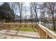 Back of house featuring a wooden deck overlooking a pond with fountains surrounded by trees in the backyard at 6420 Tunston Ln, Charlotte, NC 28269