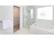 Bright bathroom featuring a shower, window, and a tub with light-colored walls and a walk-in closet at 6420 Tunston Ln, Charlotte, NC 28269