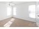 Bright bedroom featuring carpet, a ceiling fan, and three windows allowing natural light at 6420 Tunston Ln, Charlotte, NC 28269