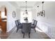 Elegant dining room with wainscoting, stylish lighting fixtures, and seating for six at 6420 Tunston Ln, Charlotte, NC 28269