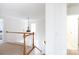 Second floor hallway featuring white walls, wood railings, a hanging light fixture, and access to other rooms at 6420 Tunston Ln, Charlotte, NC 28269