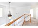Upstairs hallway featuring a pendant light fixture and a view of other rooms at 6420 Tunston Ln, Charlotte, NC 28269