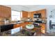 Well-lit kitchen featuring wooden cabinets, granite countertops, and modern appliances at 6420 Tunston Ln, Charlotte, NC 28269