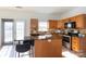 Bright kitchen with wood cabinets, an island with granite countertop, and stainless steel appliances at 6420 Tunston Ln, Charlotte, NC 28269