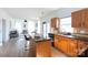 Sunlit kitchen with wooden cabinets, granite countertops, and an island with seating open to the living room at 6420 Tunston Ln, Charlotte, NC 28269