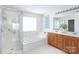 Bright bathroom with a glass shower, garden tub, double vanity, and natural light at 6420 Tunston Ln, Charlotte, NC 28269