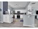 Open kitchen with modern appliances, white cabinets, peninsula bar, and sleek gray flooring at 6738 Rothchild Dr, Charlotte, NC 28270
