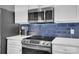 Modern kitchen featuring stainless steel microwave and oven against a blue tiled backsplash at 6738 Rothchild Dr, Charlotte, NC 28270