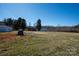 Large grassy backyard with various outbuildings and wooded area in distance at 850 Dunns Mountain Church Rd # 1, Salisbury, NC 28146