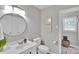 Bathroom features a clean white vanity, stylish round mirror, and updated fixtures at 905 Blalock Dr, Kings Mountain, NC 28086