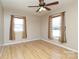 Light-filled bedroom with wood-look floors, neutral walls, and a ceiling fan at 9100 Clancy Pl, Charlotte, NC 28227