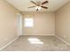 Bright bedroom with neutral walls, plush carpet, and a ceiling fan for added comfort at 9100 Clancy Pl, Charlotte, NC 28227