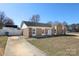 Charming brick home featuring a well-manicured lawn, a long driveway, and a classic design under a clear blue sky at 9100 Clancy Pl, Charlotte, NC 28227
