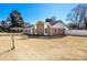 Exterior view of the brick home showing the yard, white trim, and roofline, set against a clear blue sky at 9100 Clancy Pl, Charlotte, NC 28227