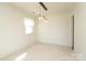Bright living room with neutral walls, a unique light fixture, soft carpet, and a window with sheer curtains at 9100 Clancy Pl, Charlotte, NC 28227