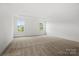 Spacious bedroom with two windows providing natural light and neutral carpeting at 9512 Coast Laurel Nw Ave # 42, Concord, NC 28027
