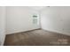 An empty bedroom offers neutral carpet and walls, a single window, and ample light at 9512 Coast Laurel Nw Ave # 42, Concord, NC 28027