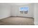 A well lit empty bedroom offers carpet, a large window, and neutral paint at 9512 Coast Laurel Nw Ave # 42, Concord, NC 28027