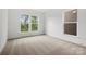 Cozy bedroom featuring two windows and wall-to-wall carpeting at 9512 Coast Laurel Nw Ave # 42, Concord, NC 28027