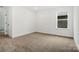 Bright bedroom with carpet, a window, and a white door at 9512 Coast Laurel Nw Ave # 42, Concord, NC 28027