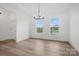 Light-filled dining area with beautiful hardwood floors, a modern chandelier, and ample space at 9512 Coast Laurel Nw Ave # 42, Concord, NC 28027