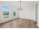 Open-concept dining room boasts hardwood floors, natural light, and contemporary chandelier at 9512 Coast Laurel Nw Ave # 42, Concord, NC 28027