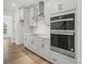 Modern kitchen with stainless steel appliances, double oven, light cabinetry, and wood flooring at 9512 Coast Laurel Nw Ave # 42, Concord, NC 28027