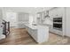 Open kitchen with a large island, stainless steel appliances, white cabinets and hardwood floors at 9512 Coast Laurel Nw Ave # 42, Concord, NC 28027