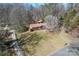 Expansive view of a brick home with a large yard and detached garage nestled in a wooded setting at 10007 Mountain Apple Dr, Mint Hill, NC 28227