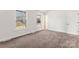 Carpeted bedroom featuring two windows offering natural light and a door to the hallway at 10007 Mountain Apple Dr, Mint Hill, NC 28227