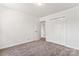Well-lit carpeted bedroom featuring a closet and a door to the hallway at 10007 Mountain Apple Dr, Mint Hill, NC 28227