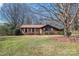 Charming brick home featuring a well-manicured lawn and mature trees, creating an inviting curb appeal at 10007 Mountain Apple Dr, Mint Hill, NC 28227