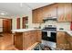 Functional kitchen with wood cabinets, stainless steel range, and adjacent dining space at 1069 W Rebound Rd, Van Wyck, SC 29720