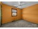 This bedroom features orange walls, carpeted floors, a ceiling fan and a window with blinds at 108 Donna Ave, Gastonia, NC 28052