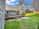 Wooden deck area with steps down to a stone patio in the green, spacious backyard at 111 Oakwood Dr, Kings Mountain, NC 28086