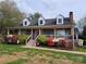 Charming home with a welcoming front porch, dormer windows, and colorful landscaping at 111 Oakwood Dr, Kings Mountain, NC 28086