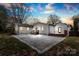 Backyard featuring a modern concrete patio, dark wood decks, and white trim on a home's exterior at dusk at 1121 S Edgemont Ave, Gastonia, NC 28054