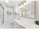 Bright bathroom features white tile, gold fixtures, and a large mirror for a modern, elegant design at 1121 S Edgemont Ave, Gastonia, NC 28054