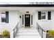 Inviting front porch with black door, white painted brick, and black railings on a sunny day at 1121 S Edgemont Ave, Gastonia, NC 28054