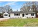Charming single-story home with fresh white paint, black shutters, manicured lawn and complementing detached garage at 1121 S Edgemont Ave, Gastonia, NC 28054