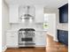 Close-up of the stainless steel range and hood in a kitchen with white cabinets at 1121 S Edgemont Ave, Gastonia, NC 28054