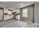 Modern kitchen with white cabinets, gray countertops, stainless steel appliances, and stylish wood-look tile flooring at 113 Galilean Rd, York, SC 29745