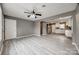 Open-concept living space with plank floors, ceiling fan, and seamless flow into the modern white kitchen at 113 Galilean Rd, York, SC 29745