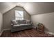 A bonus room showcasing a large sofa, natural light, sloped ceilings and wood floors at 11427 Lamoille Ln, Charlotte, NC 28278