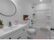Bright bathroom featuring a white vanity, circular mirror, and a shower-tub combo at 116 11Th St, Spencer, NC 28159