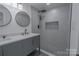 Bathroom featuring a double vanity, modern mirrors, and a tiled walk-in shower at 116 11Th St, Spencer, NC 28159